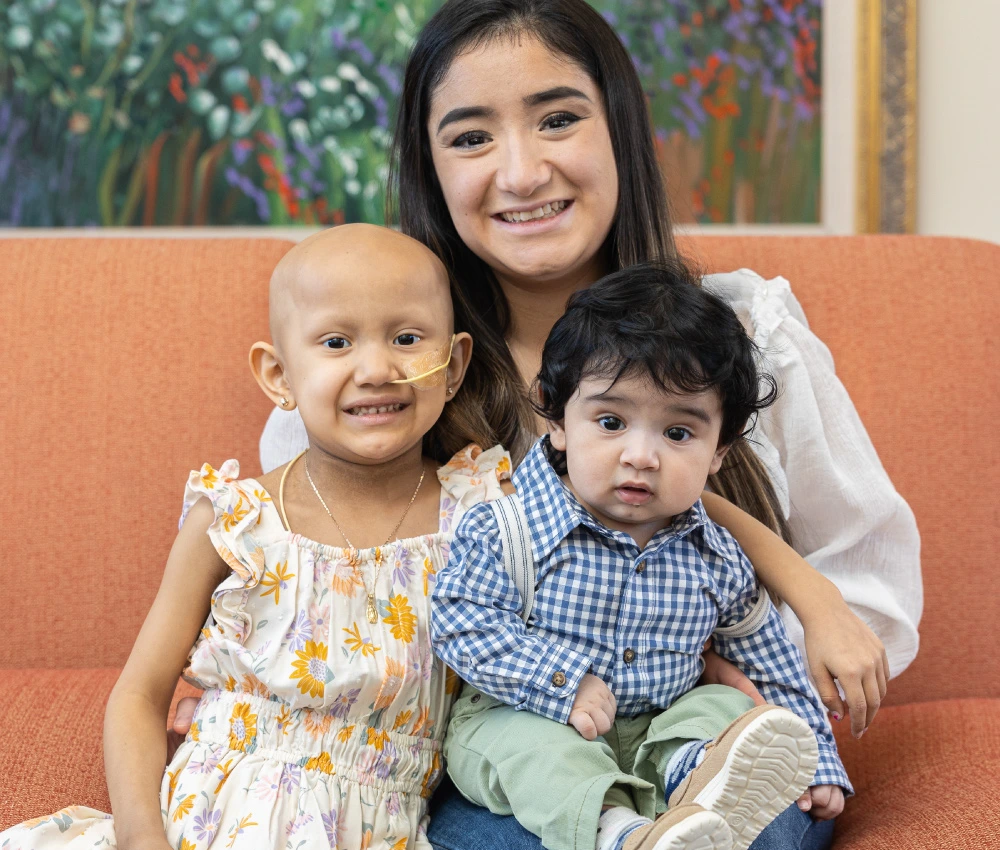 mother with two young children sitting together on a couch