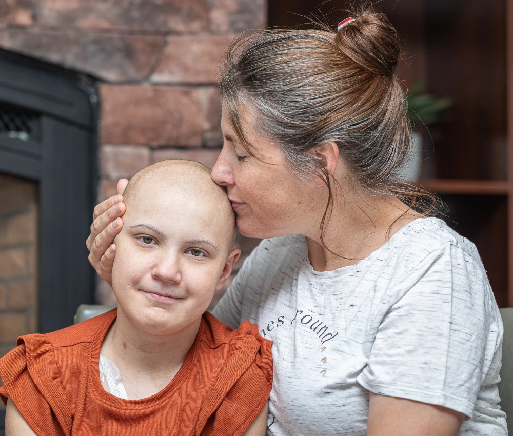 mother kissing daughter's' shaved head